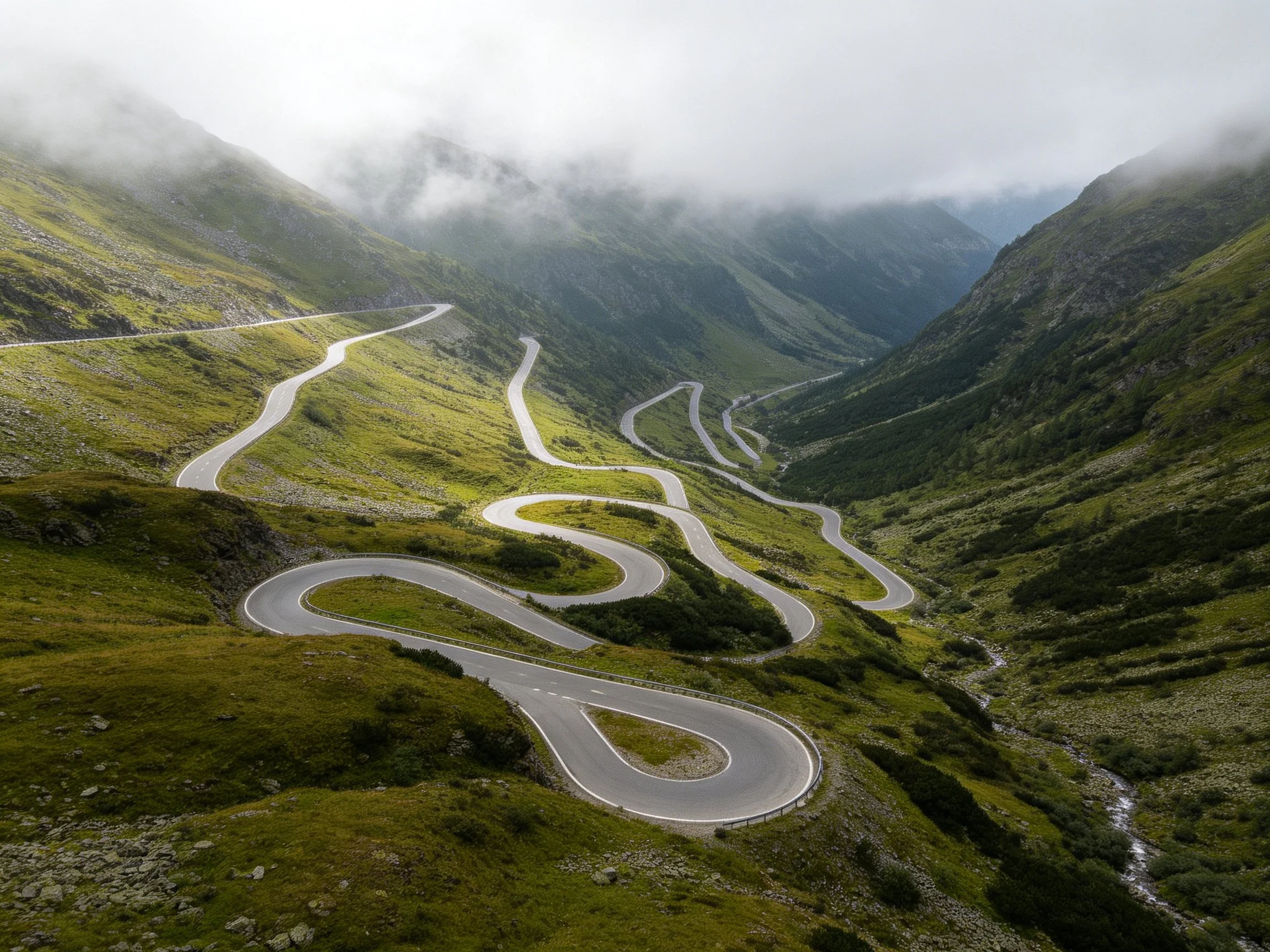 Winding Mountain Road with Multiple Switchbacks Through Green Valleys