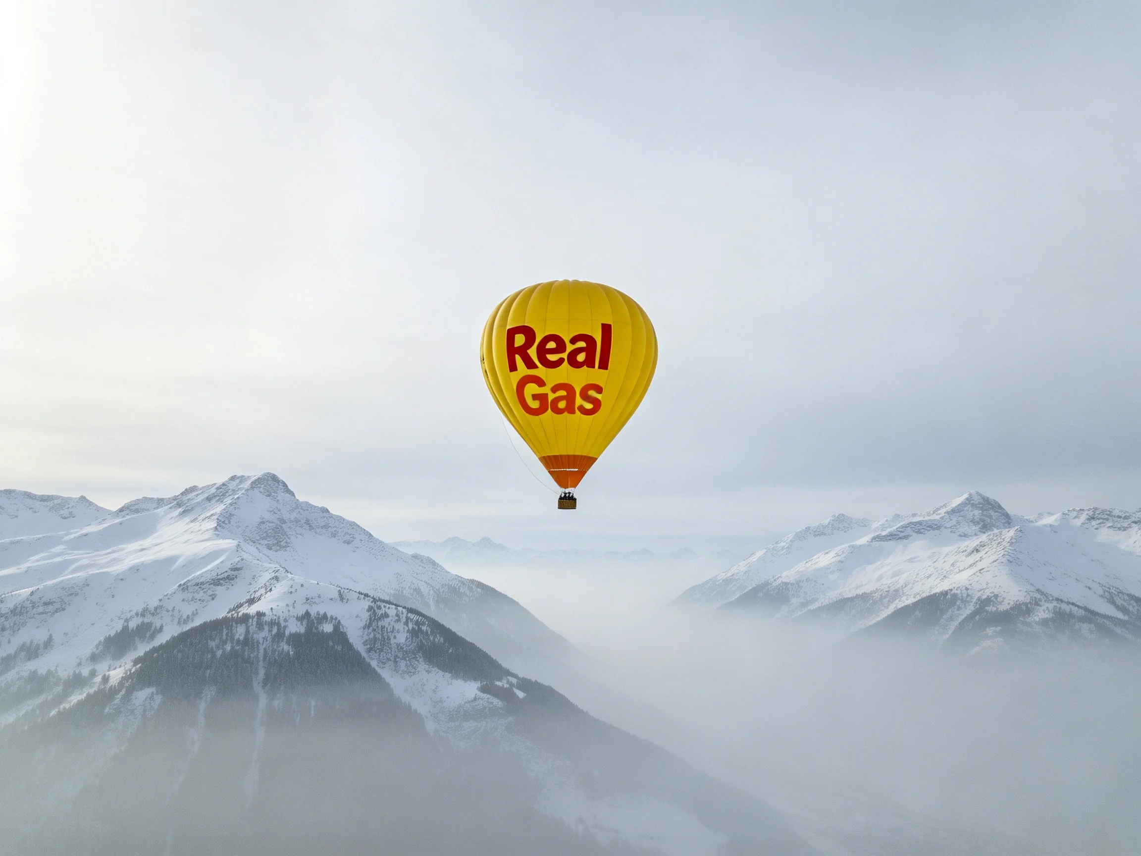 Yellow hot air balloon labeled Real Gas floats above snow-covered mountain peaks
